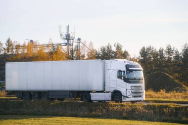 Yaz aylarında asfalt yolda giden yarı kamyon.