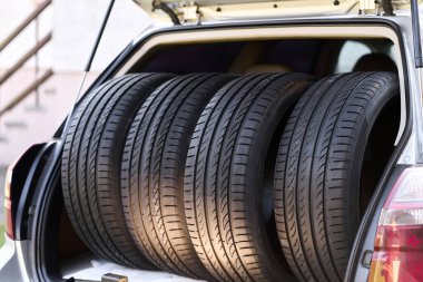 Açık arabanın bagajına dört adet yaz lastiği yerleştirilmiş.