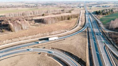 Kırsal kesimden geçen beyaz bir kamyonet, yukarıdan gelen hava manzarası kamyonların gölgesini gösteriyor.