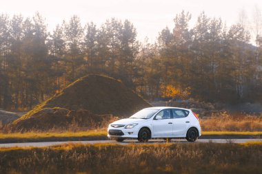 Araba sessiz kırsal yolda hızla ilerliyor.