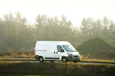 Teslimat aracı doğaya yakın asfalt yolda.