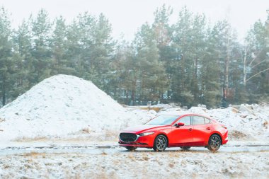 Kırsal yolda kırmızı hibrit SUV hareket halinde