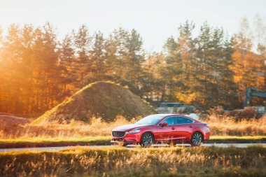 Yeşil kırsal arka plana sahip şık bir sedan.