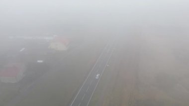 Beyaz araç kalın sisli havada seyahat ediyor.