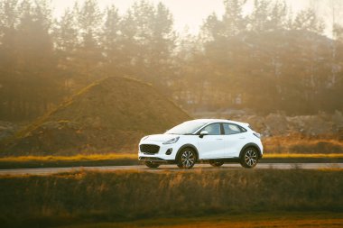 Gün batımında kırsal alanda gezinen arazi aracı.