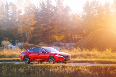 Sedan hibrid yeşilliklerle kırsal alanda ilerliyor.