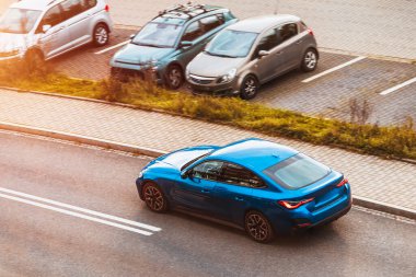 Lüks araç kaldırım kenarından geçiyor.