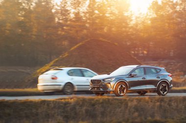 Gün batımında kırsal yolda giden SUV.