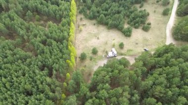 Park halindeki karavanı çevreleyen orman ağaçları