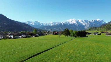 Kar zirvelerinin eteklerindeki kır evleri