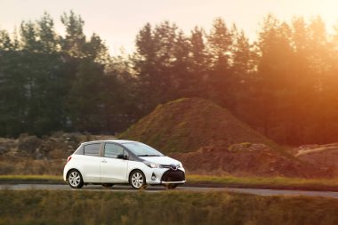 Kırsalda siyah bir araba sürüyor.