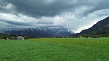 Dağlarla ve çiçek açan çimenliklerle dolu bahar manzarası
