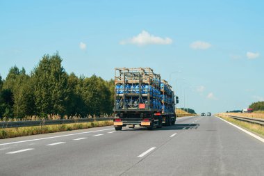 Kargo kamyonu doldurmak için propan konteynırları taşıyor.