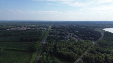 Yoğun yeşil ormanın ortasında paralel demiryolu ve yol