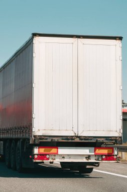 Kargo kamyonu açık mavi gökyüzü yolunda..