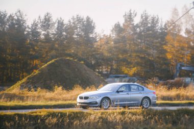 Çimenli arazide modern araba sürüyor.