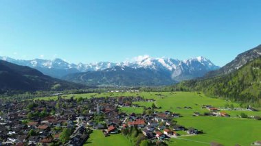 Bulutlu gökyüzünün altındaki renkli alp köyü