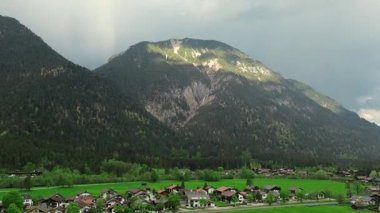 Bahar mevsiminde köy manzarasına hükmeden nefes kesici Bavyera Alpleri