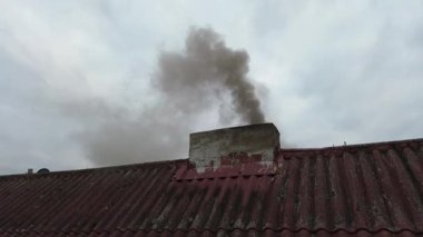 Evin bacasından siyah duman yükseliyor.