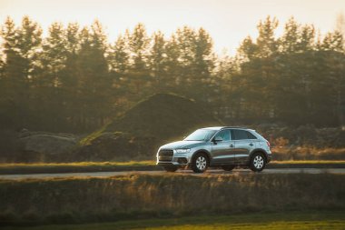 Şık yönetici arabası gün batımında seyahat ediyor.