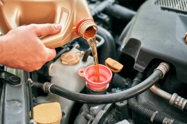 Araç motoruna yağ dökülüyor.