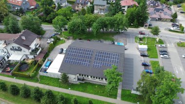 Otoparkı ve ağaçları olan güneş enerjili bir bakkal.