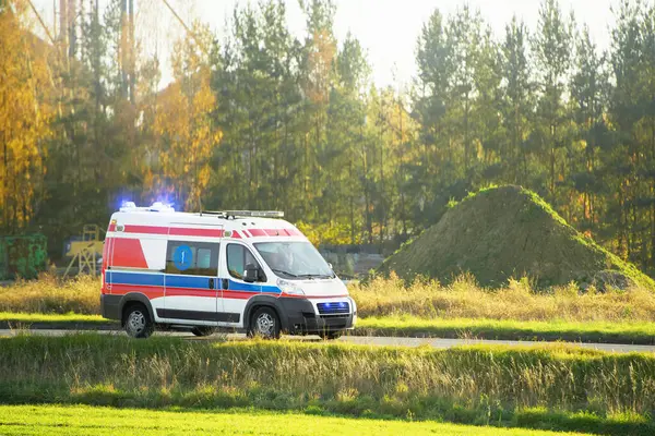 Kırsal yolda parlak sarı bir ambulans sürüyordu.