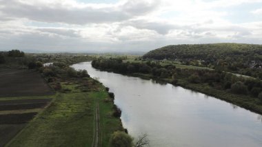 Bereketli ağaçlar ve mavi suyla sakin nehir kenarı