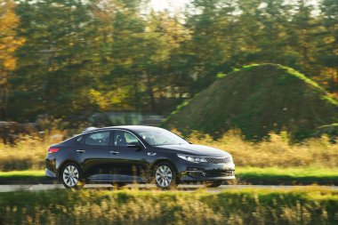 Kırsal yolda giden modern sedan.