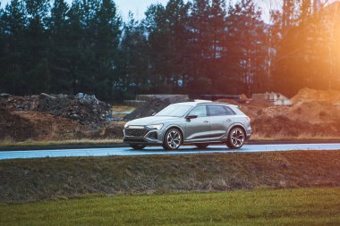 Yeşil manzaralı kırsal yol boyunca giden modern SUV