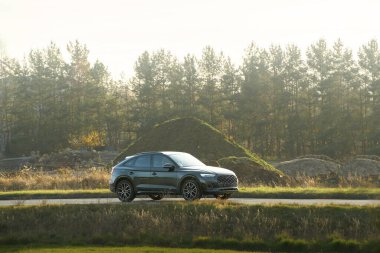 Gün batımında ormanda gezinen bir araç.