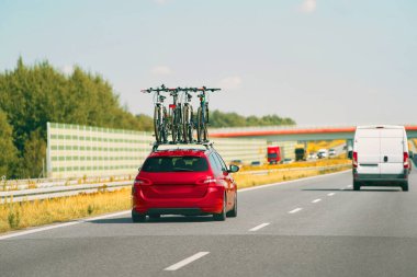 Açık otoyolda bisikletli bir araba.