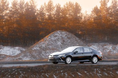 Kırsal yolda siyah lüks bir sedan.