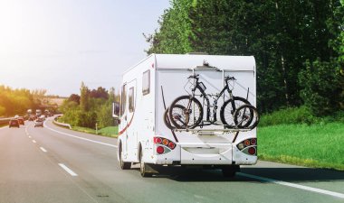 Alp çayır ve kulübelerin yanından geçen bir karavan.