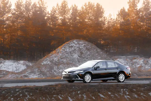 Kırsal yolda siyah lüks bir sedan.