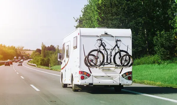 Alp çayır ve kulübelerin yanından geçen bir karavan.