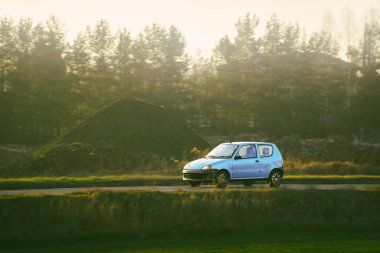 Kırsal alanda küçük bir araba geziniyor.