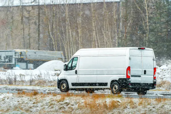 Manzaralı arka planı olan kargo aracı yolda.