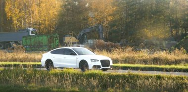 Beyaz güçlü spor araba sahadan geçiyor.