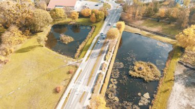 Güz mevsiminde iki gölet arasındaki tepeden bakan yol