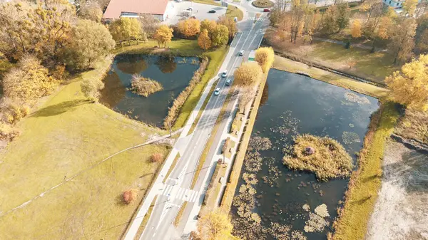 Güz mevsiminde iki gölet arasındaki tepeden bakan yol