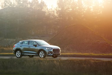 Huzurlu kırsal yolda giden bir mülk arabası.