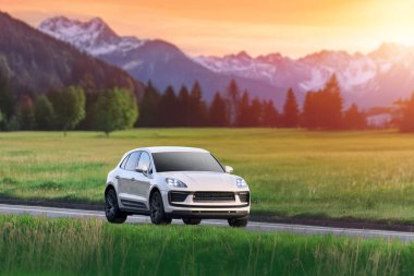 Çimenli tepeciklerin ve ağaçların yanından geçen arazi aracı