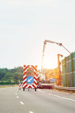 Yol üzerinde uyarı işareti olan bir inşaat aracı