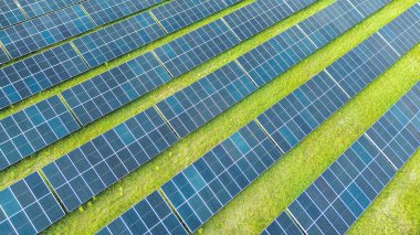 Güneş panellerinin sıraları yeşil alanda güneş ışığını yakalıyor