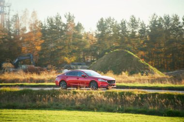 Parlak güneşli gökyüzünün altında giden güçlü bir sedan.