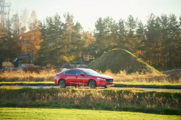 Parlak güneşli gökyüzünün altında giden güçlü bir sedan.