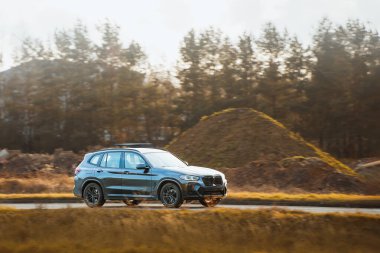 Akşam vakti kırsal yolda araba parlıyor.