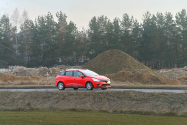 Parlak kırmızı otomobil kırsal alanda seyahat ediyor.