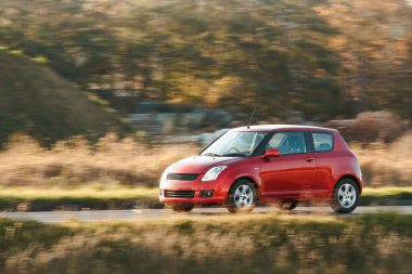 Manzaralı kırsal bir yolda araba sürüyor.